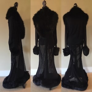 May include: A black sheer robe with a fur collar, cuffs, and hem. The robe has a long, flowing silhouette.