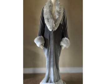 May include: A long gray velvet robe with a white faux fur collar and cuffs. The robe has a shawl collar and a tie belt.