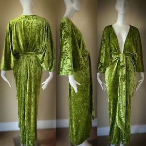 May include: A long green velvet robe with a deep V-neckline and wide sleeves. The robe is tied at the waist with a sash.