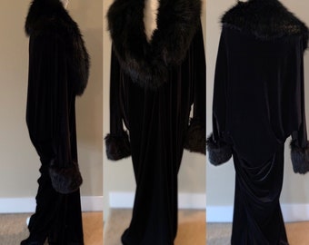 May include: A long black velvet robe with a large black faux fur collar and cuffs. The robe has a fitted bodice and a flowing skirt.