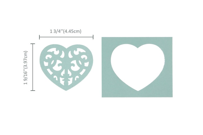May include: A light blue heart-shaped stencil with a decorative filigree design. The stencil measures 4.45 cm wide and 3.97 cm tall.