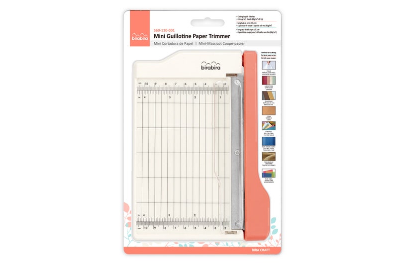 May include: A white and orange mini guillotine paper trimmer with a metal blade. The trimmer has a ruler with markings in inches and centimeters. The packaging includes instructions for use and a list of materials that can be cut with the trimmer.