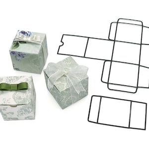 May include: Three small square gift boxes with different floral patterns and ribbon bows. A black metal template for making a similar box is also shown.