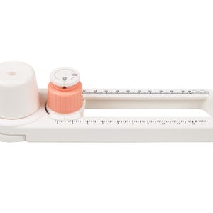 Op de afbeelding: Witte plastic cirkelknipper met een liniaal en een knop om de grootte van de cirkel aan te passen. De cirkelknipper heeft een maximale cirkelgrootte van 25,4 cm.