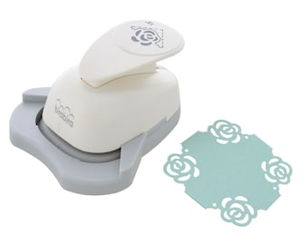 May include: A white and gray paper punch with a rose design. The punch is used to create decorative paper shapes. A sample of the punched paper is shown in the image. The paper is light blue and has a rose design.