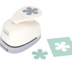 May include: A white paper punch with a gray flower design on the top. The punch is used to create paper flowers. The image shows the punch, a paper flower, and a piece of paper with a flower cut out.