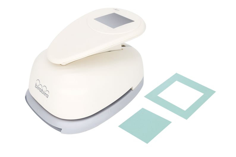 May include: White paper punch with a gray base. The punch is designed to create square frames. Two sample frames are shown, one with a white interior and one with a solid teal interior. The punch is labeled "birabira".