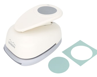May include: White circle punch with a gray handle and a gray circle on the top. The punch is on a white background with two samples of circles punched from paper. One circle is on a white background and the other is on a light blue background.