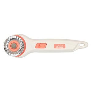 May include: A white rotary cutter with coral-coloured safety button and accents. The blade is silver and circular. The handle has the brand name "birabira" printed in coral.