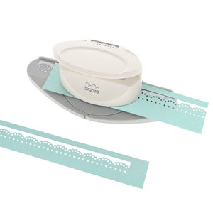 May include: A white and grey paper punch with a light blue paper strip being punched. The punch has the brand name "birabira" printed on it. The punched paper strip has a decorative scalloped edge.