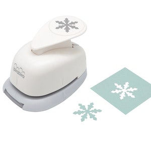 May include: White snowflake paper punch with a gray snowflake design on the top. The punch is on a white background with two punched out snowflakes on a light blue background.