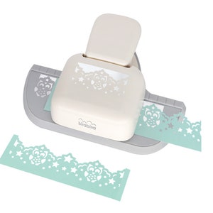 May include: A white and grey paper punch with a light blue border design featuring owls and stars. The punch is used to create decorative edges on paper.
