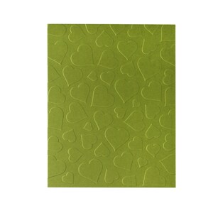 Puede incluir: Una hoja de papel de cartulina verde con un patr&oacute;n en relieve de corazones.