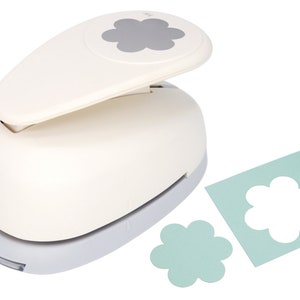 May include: White paper punch with a gray flower design. The punch is used to create flower-shaped cutouts from paper. Two flower-shaped cutouts are shown, one in white and one in light blue.