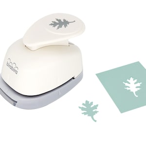 May include: White paper punch with a gray handle and a gray leaf design on the top. The punch is used to create leaf shapes from paper. A green leaf shape is shown next to the punch.
