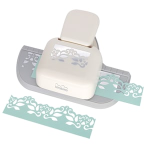 May include: A white and grey paper punch with a floral design. The punch is used to create decorative edges on paper. The punch is shown with a sample of the design it creates.