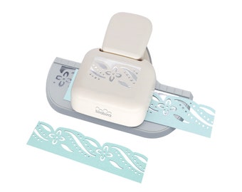 May include: A white and grey paper punch with a blue paper strip featuring a floral design. The punch is labelled "birabibra".