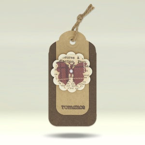 May include: A brown paper gift tag with a brown butterfly design. The butterfly is made of paper and has a red, white and black plaid pattern. The tag has the word "romance" printed on it.