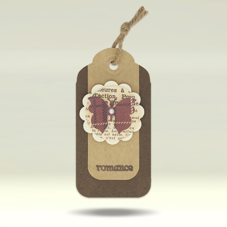 May include: A brown paper gift tag with a brown butterfly design. The butterfly is made of paper and has a red, white and black plaid pattern. The tag has the word "romance" printed on it.