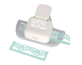 May include: A white and gray paper punch with a decorative border design. The punch is used to create a border on paper. The punch is shown with a sample of the border it creates.