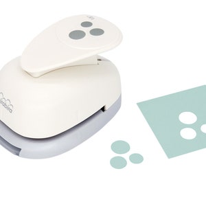 May include: White paper punch with a grey base and a grey handle. The punch is designed to create three circles at once. The punch is shown next to a sheet of paper with three circles punched out and three individual circles.