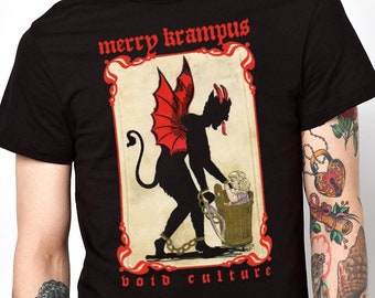 May include: Black t-shirt featuring a graphic of Krampus, a horned figure with red wings, holding a child in a basket. The text "merry krampus" and "void culture" are printed above and below the graphic in red.