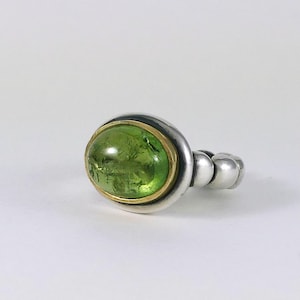 Beautiful grass green tourmaline set in gold on a heavy designer silver ring