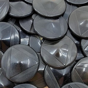 May include: A pile of black buttons with a triangular design. The buttons are shiny and have a raised centre.