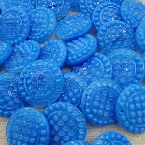 May include: A collection of bright blue, round buttons with a textured, bubble-like design. The buttons have a raised, circular pattern around the edges and a small hole for sewing. These buttons are suitable for various sewing and craft projects.