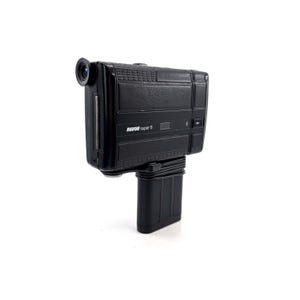 May include: A black Revue Super 8 film camera with a textured body and a lens on the front. The camera is mounted on a black stand.
