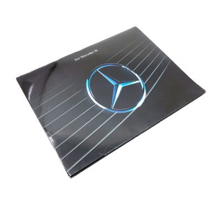 May include: A black and silver brochure with the Mercedes-Benz logo and the text "Der Mercedes SL" in white.