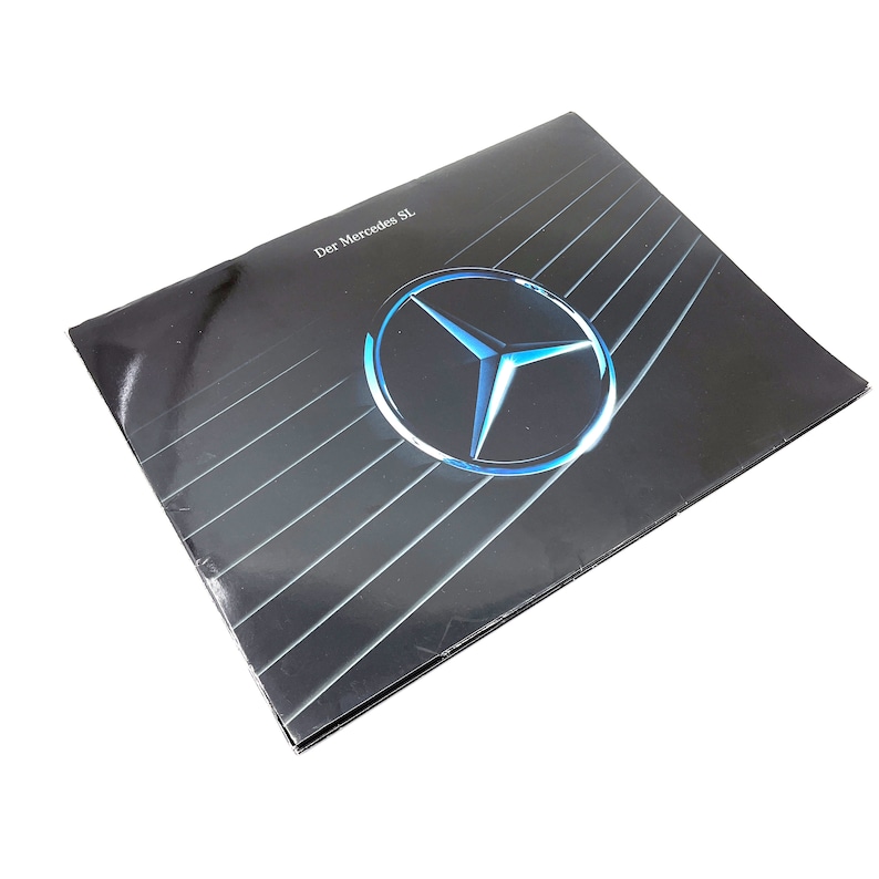 May include: A black and silver brochure with the Mercedes-Benz logo and the text "Der Mercedes SL" in white.