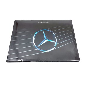 May include: A black and silver brochure with the text "Der Mercedes SL" and a blue Mercedes-Benz logo.