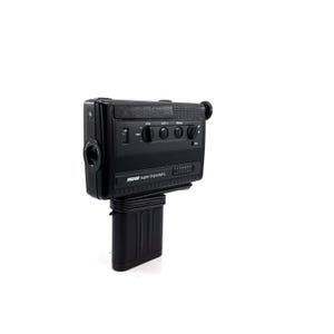 May include: A black Super 8 pocket L camera by Revue. The camera has a built-in microphone, zoom lens, and a viewfinder. The camera is mounted on a black battery pack.