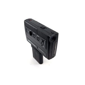 May include: A black vintage video camera with a lens on the front and a series of buttons and dials on the top.