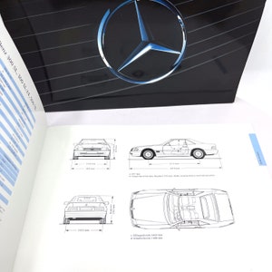 May include: A black and white line drawing of a Mercedes-Benz SL-Class car. The drawing shows the car from the front, side, and rear views. The dimensions of the car are labeled in millimeters.