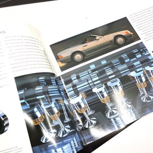 May include: A close-up of a silver car engine with a detailed illustration of the engine's inner workings. The image shows the pistons, valves, and other components of the engine.