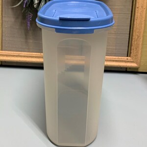 May include: A clear, rectangular food storage container with a light blue lid. The container has a translucent body and a rectangular shape. The lid is a solid light blue colour. The container is designed for storing dry goods.
