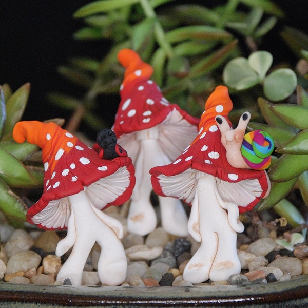 Champignons sculptés en argile du jardin des fées avec une casquette rouge et orange et un ami escargot ou coccinelle