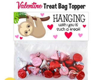 May include: Valentine's Day treat bag topper featuring a sloth illustration hanging from a branch. The text reads "HANGING with you is such a treat!" The bag contains wrapped sweets. The design is for a 15 cm zip-seal bag.