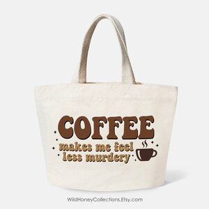 May include: A white canvas tote bag with brown text that reads "COFFEE makes me feel less murdery" and a brown coffee cup icon.