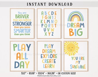 May include: Six framed wall art prints featuring colorful typography and illustrations. Designs include an alphabet, a rainbow with the text Dream Big, a sun with the text You Are My Sunshine, and motivational phrases like Play All Day and You Are Braver.