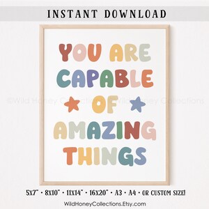 May include: A printable wall art print with the text "You are capable of amazing things" in colorful, rounded letters. The text is in a rainbow color scheme with a star on either side of the word "of".