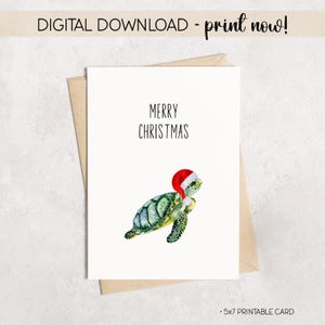 May include: A white greeting card with the text "MERRY CHRISTMAS" and a watercolor illustration of a green sea turtle wearing a red Santa hat. The card is a 5x7 printable card.