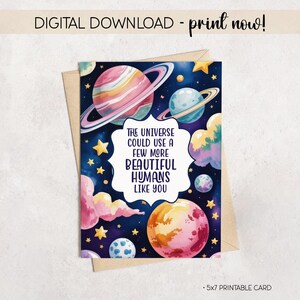 Può includere: Biglietto digitale scaricabile con un'illustrazione ad acquerello di pianeti, stelle e nuvole nei toni del rosa, blu e giallo. Il biglietto recita "THE UNIVERSE COULD USE A FEW MORE BEAUTIFUL HUMANS LIKE YOU." Il biglietto misura 12,7 x 17,8 cm.