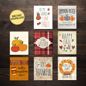 May include: A collection of fall-themed printable art cards. Designs include pumpkins, autumn leaves, and phrases like "Happy Fall y'all" and "Pumpkin Spice makes everything nice!" The cards are on a dark wood background.