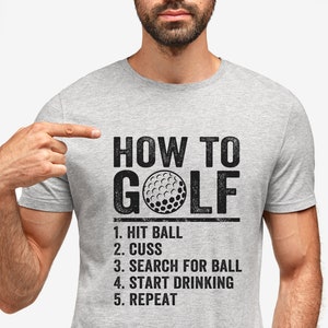 Pu&ograve; includere: Una maglietta grigia con una grafica nera che dice "HOW TO GOLF" con un'immagine di palla da golf e un elenco di passaggi: "1. HIT BALL, 2. CUSS, 3. SEARCH FOR BALL, 4. START DRINKING, 5. REPEAT."