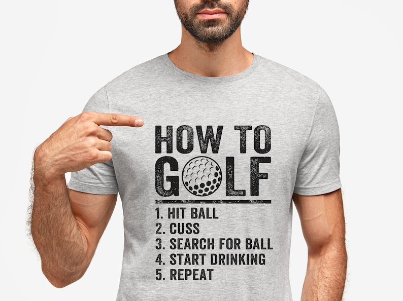 Pu&ograve; includere: Una maglietta grigia con una grafica nera che dice "HOW TO GOLF" con un'immagine di palla da golf e un elenco di passaggi: "1. HIT BALL, 2. CUSS, 3. SEARCH FOR BALL, 4. START DRINKING, 5. REPEAT."