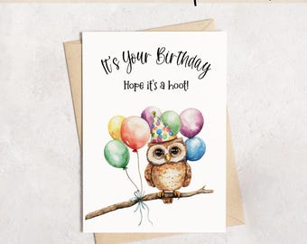 May include: A white greeting card featuring a brown owl wearing a colorful polka-dot party hat, perched on a branch with a cluster of multi-colored balloons. The text reads It's Your Birthday Hope it's a hoot! The card is 5x7 inches in size.