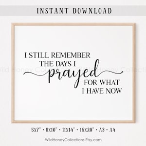 May include: A framed print with the text "I STILL REMEMBER THE DAYS I prayed FOR WHAT I HAVE NOW" in black script. The print is in a light wood frame and includes size options: 5x7", 8x10", 11x14", 16x20", A3, and A4.